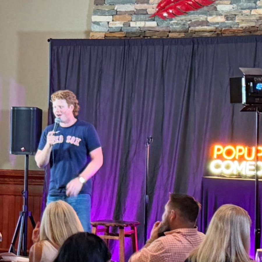 A packed room watching a comic perform